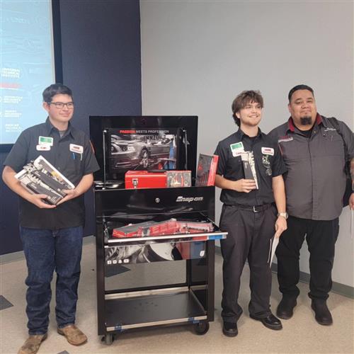 Two students and a teacher with tools and a toolbox